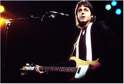 Paul McCartney performing live with his band Wings.