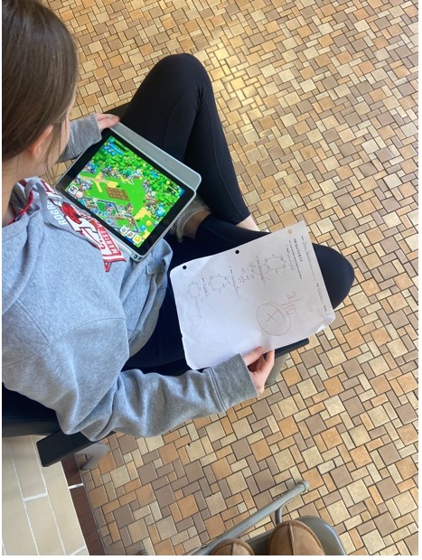 A student playing games while they do their homework.  