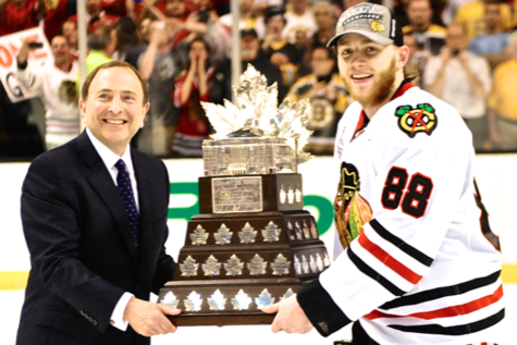Patrick Kane (right) accepting the Conn Smythe Trophy from NHL commissioner Gary Bettman (left) for being Stanley Cup Playoffs MVP in 2013