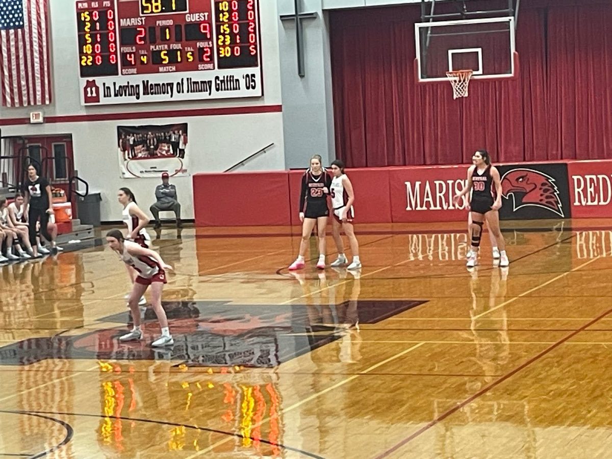 The Marist Redhawks, Grace Harmon, Madison Vrdolyak, and Lucy Cosme on defense against the Lincoln-Way Central Knights in the first quarter.


