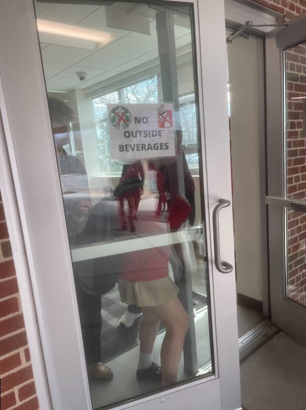 Marist students exit out of the science wing door with the no outside drinks sign