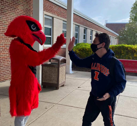 RedHawk Mascot high-fives masked student. (Credit: Marist Website)