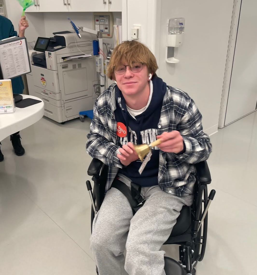 Jake ringing the graduation bell at Shirley Ryan Ability Lab
