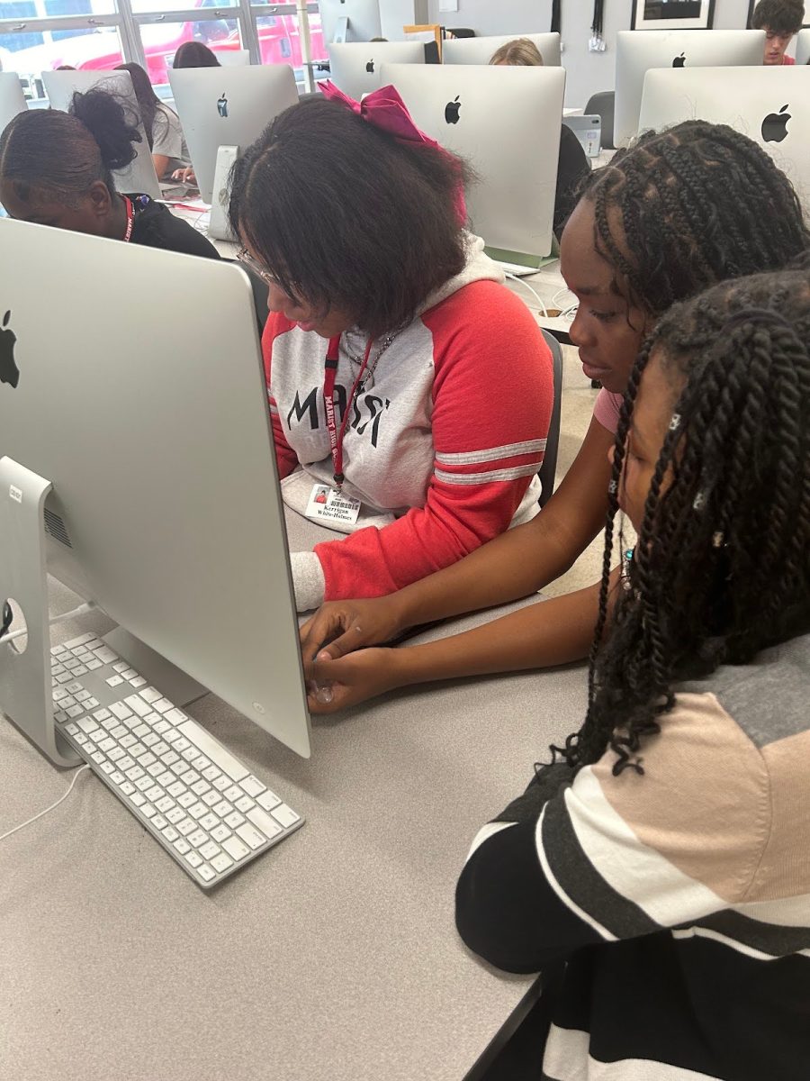 Freshman Kerrigan White-Holmes sitting with her shadows in journalism  class