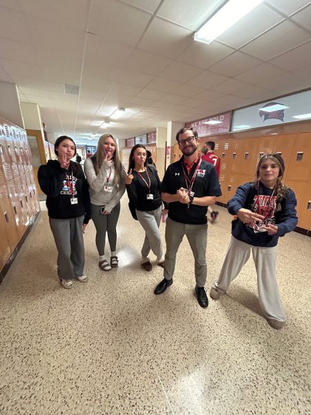 Students Carsyn Smith, Brooklyn Reyna, Ava McGlynn, and Isabella Fratto snap a picture with Mr. Berta before geometry class.