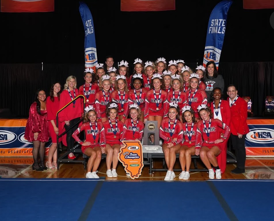 The Marist Varsity Cheer Team posing for a photo with Coach Miller and Mrs. Dunneback after their win