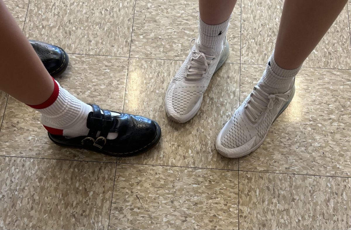 Student wearing Dr. Martens (left) and another in gym shoes (right)