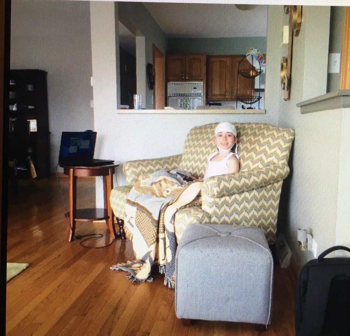 Ava sitting on the couch being recorded while going through a brain test called an EEG, which records the electrical waves in the brain  