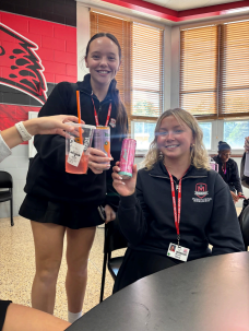 Marist seniors Sophia Landers and Reese Olsen holding up their energy drinks during period 5 lunch