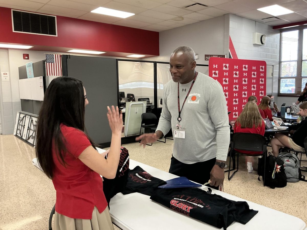 Mr. Rob Topps with a student selling Rowdie t-shirts at lunch time