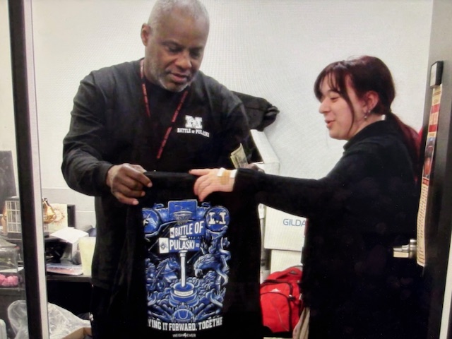 Coach Rob Topps handing Sarah Basic a Battle of Pulaski T-shirt 