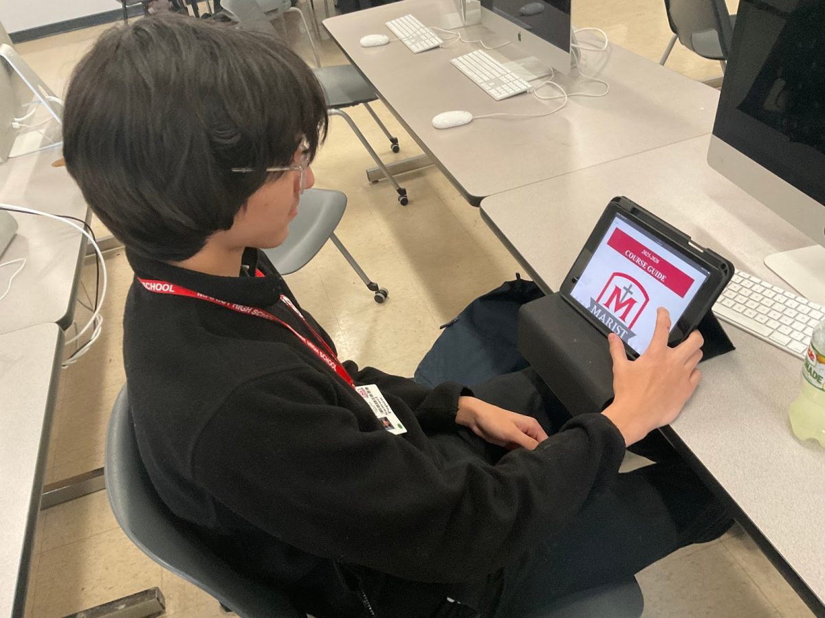 Senior Sam Popow scrolling through the Marist course guide