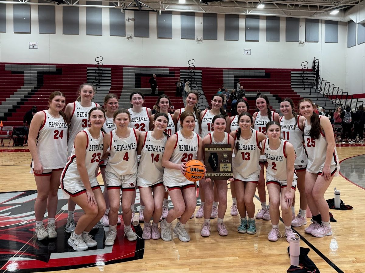 The Marist RedHawks varsity girls basketball team poses with their regional champion’s plaque (Credit: Lucy Cosme #15)