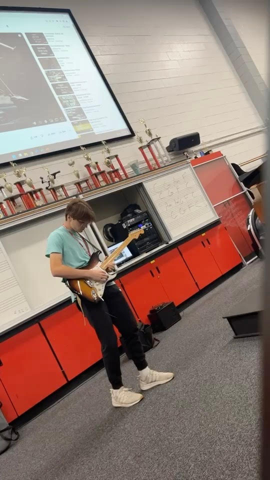 Guitar Club leader Billy Petto playing at a meeting 