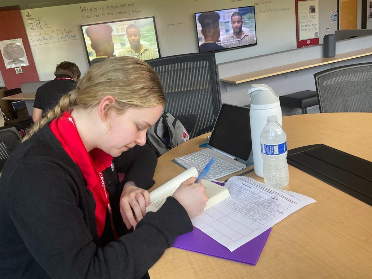 Senior Julia Simpson doing her homework during a free period instead of taking out her phone like she would have done in years past